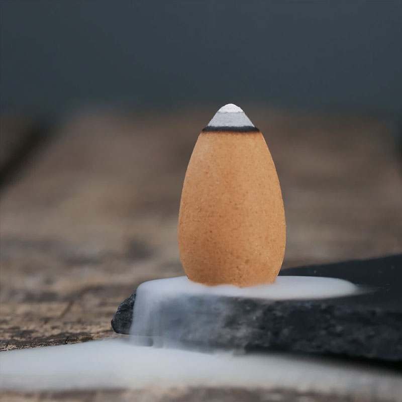 Incense cone on a stone surface with a blurred natural background