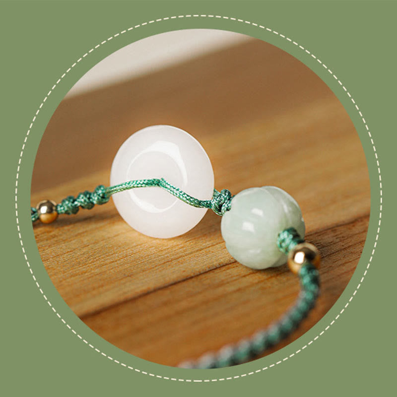 Jade bracelet with white and green beads on a wooden surface