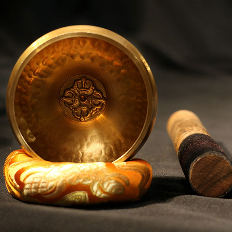 Decorative gong with intricate designs on a dark background