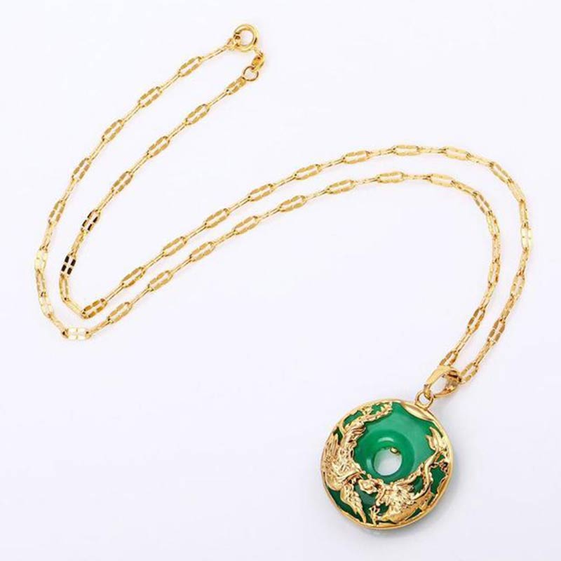 Gold necklace with a green pendant on a white background