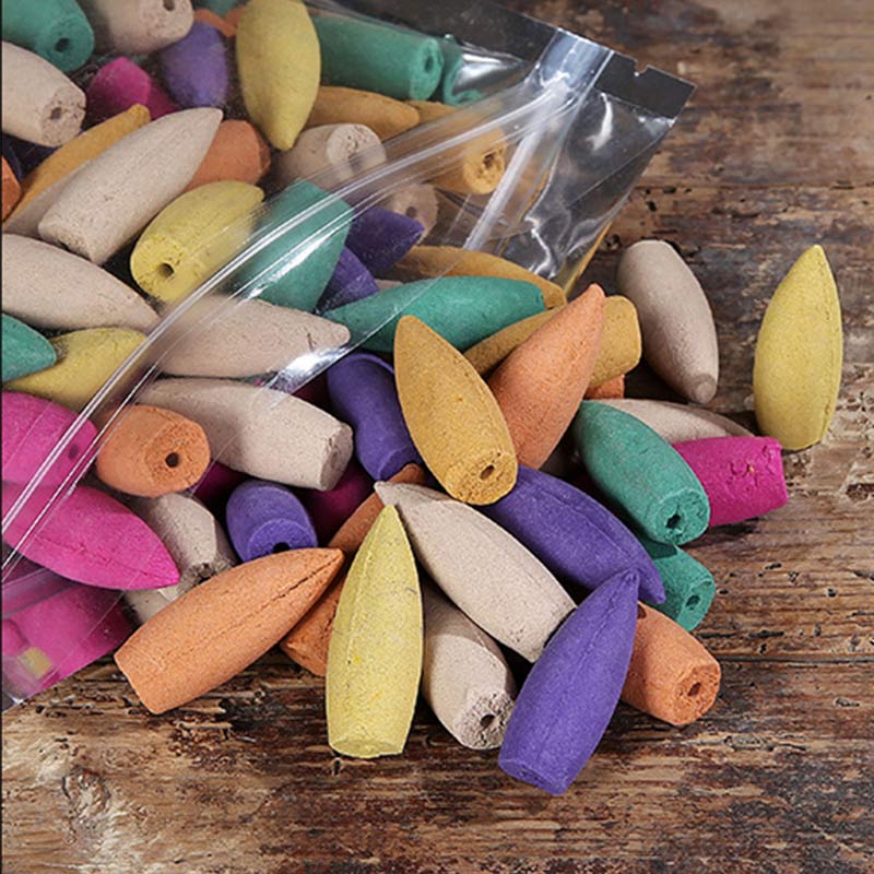 Colorful incense cones in a clear plastic bag on a wooden surface