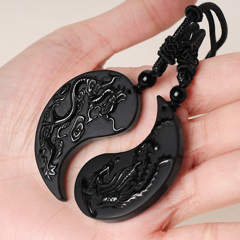 Black dragon pendant on a hand with a beige background