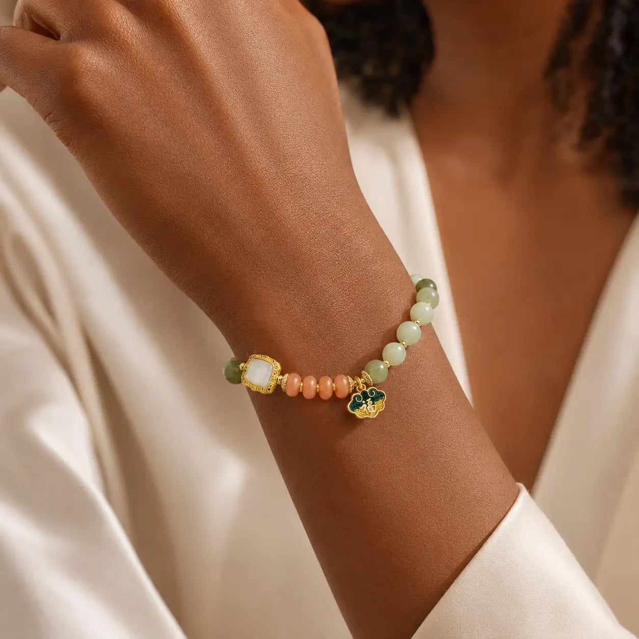 Golden Silk Jade Beaded Bracelet worn with orange accents and gold charm