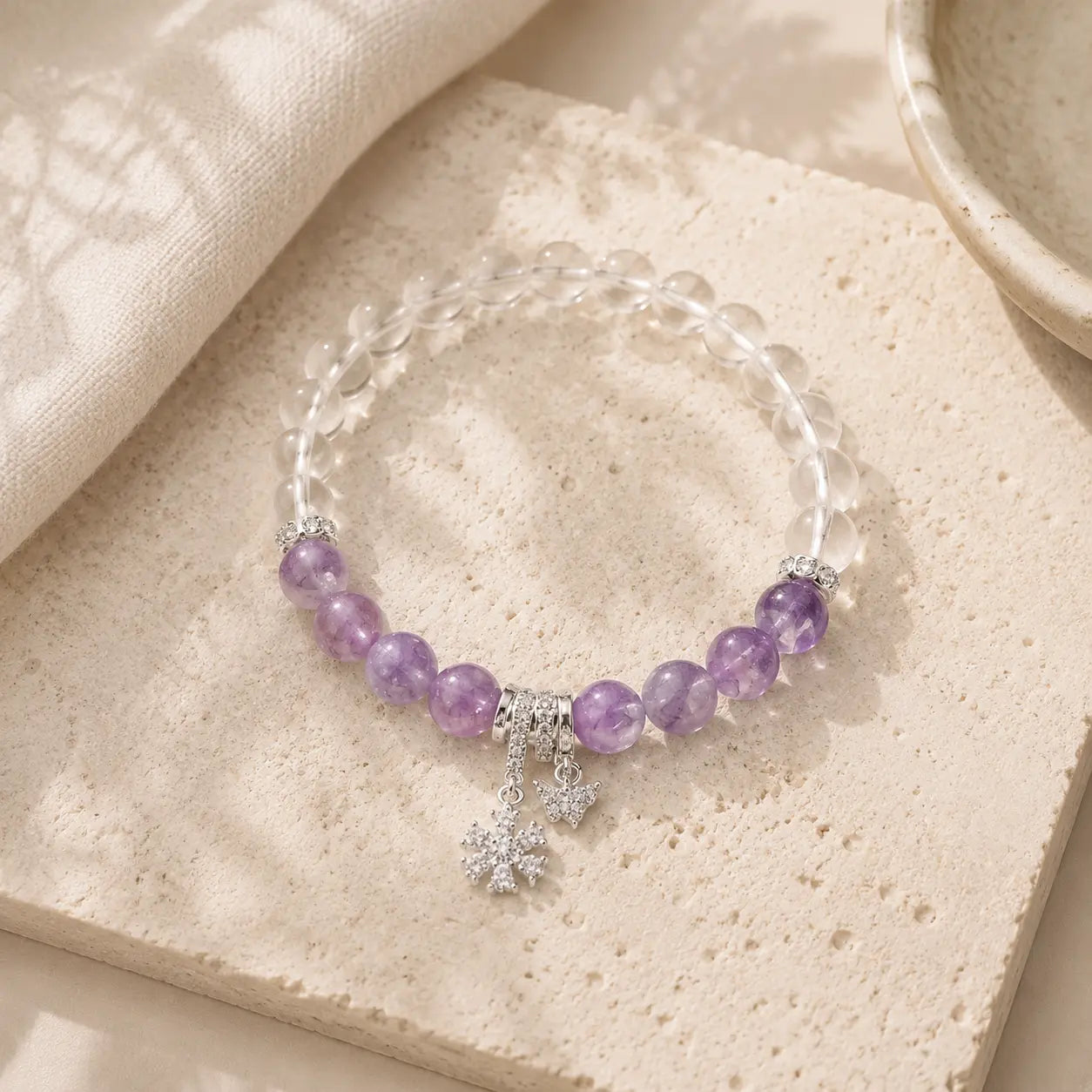 Amethyst Zircon Beaded Bracelet on textured stone with silver charms