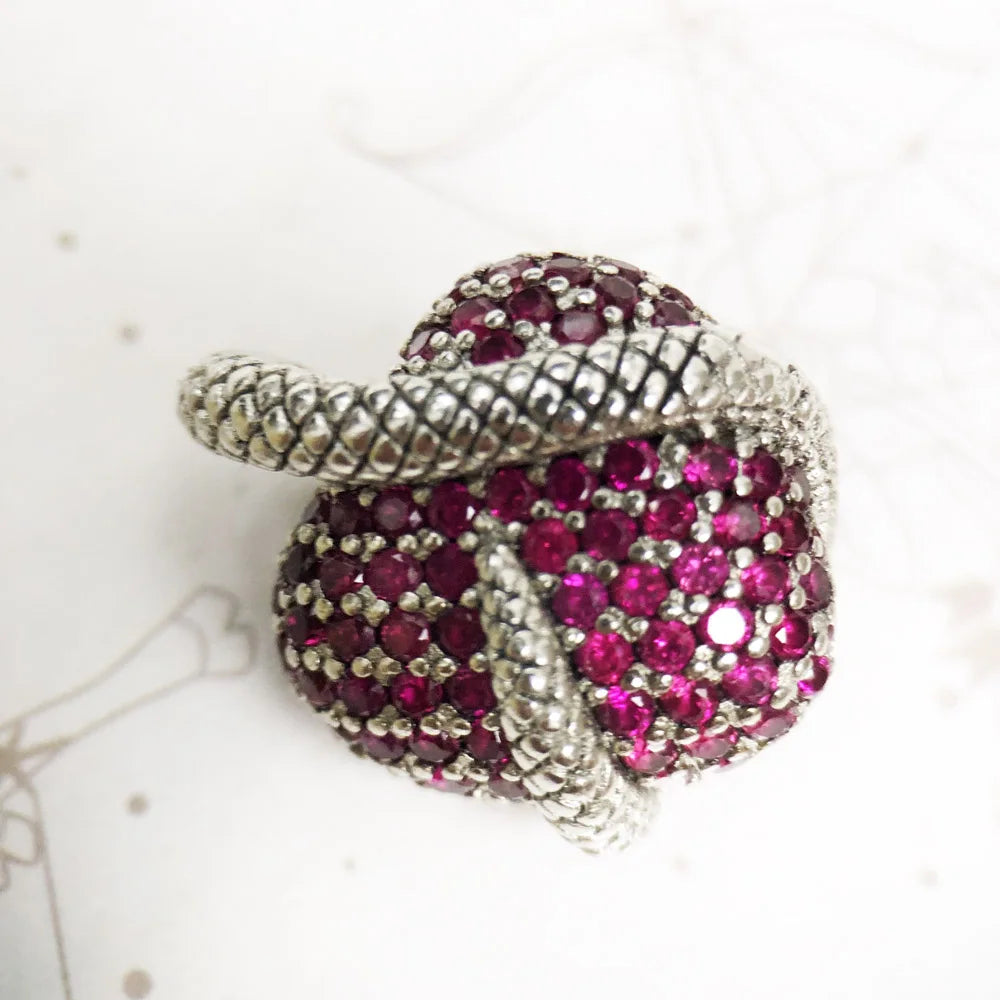 Silver and pink gemstone brooch on a white background