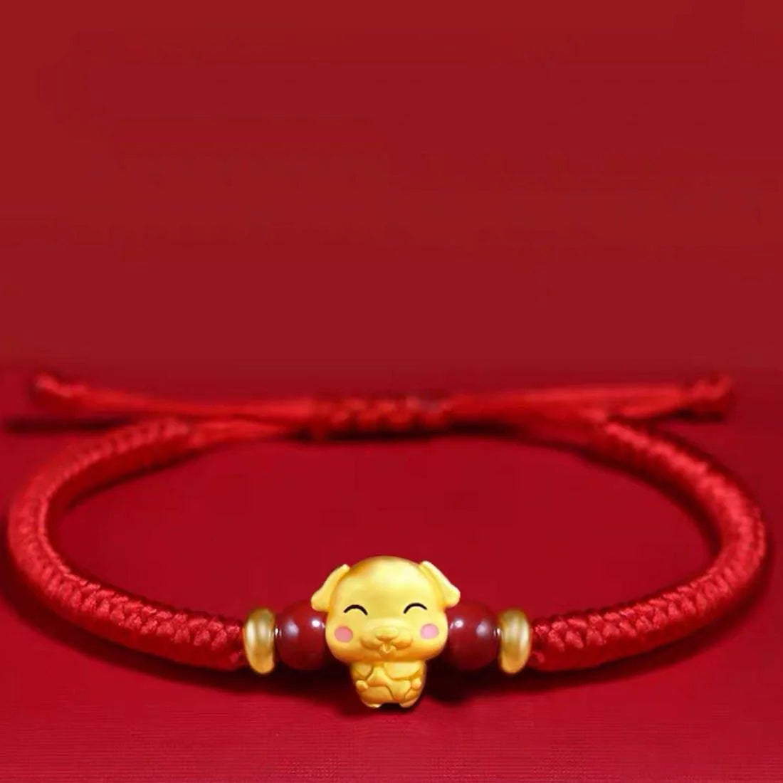 Red bracelet with a gold charm on a red background