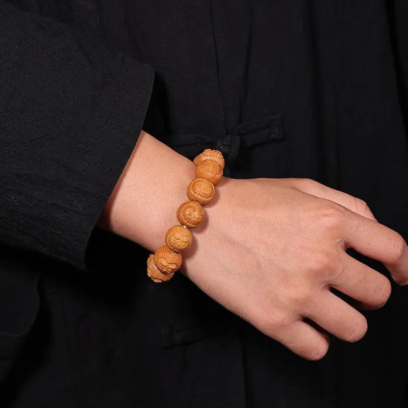 Hand wearing a wooden beaded bracelet against a black background