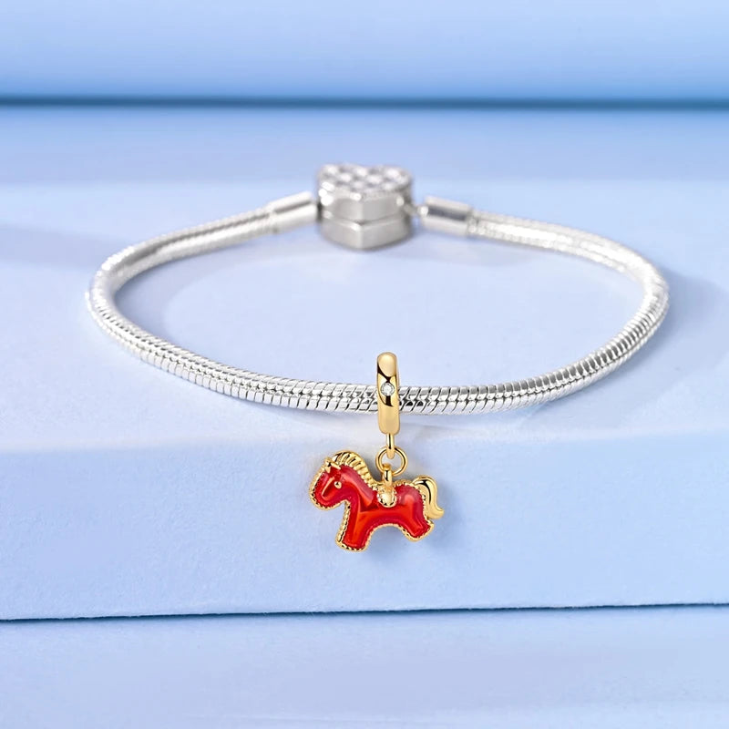 Silver bracelet with a red horse charm on a light blue background