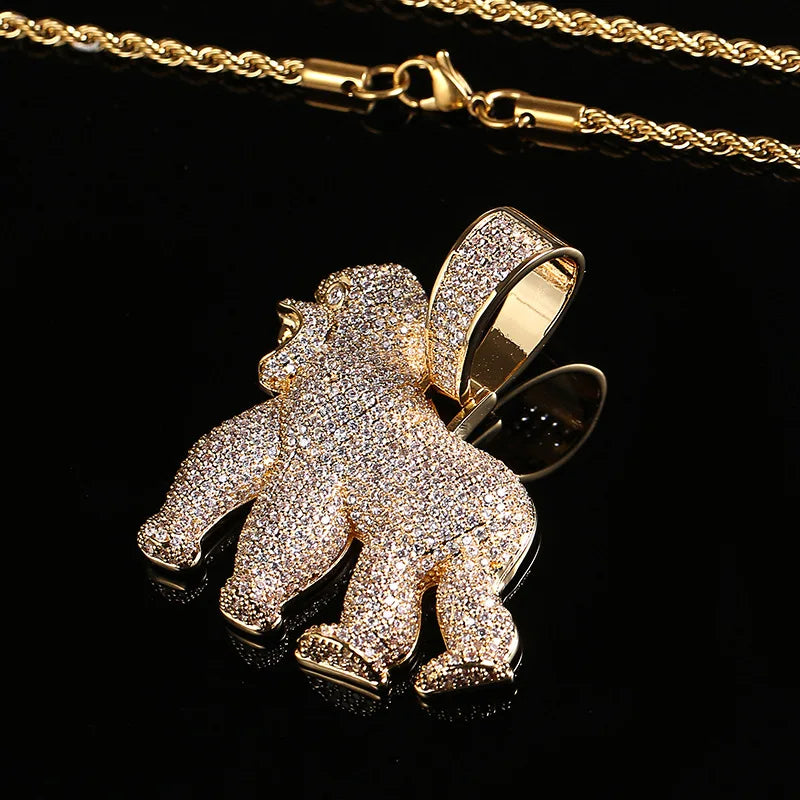 Gold gorilla pendant with diamond accents on a gold chain against a black background