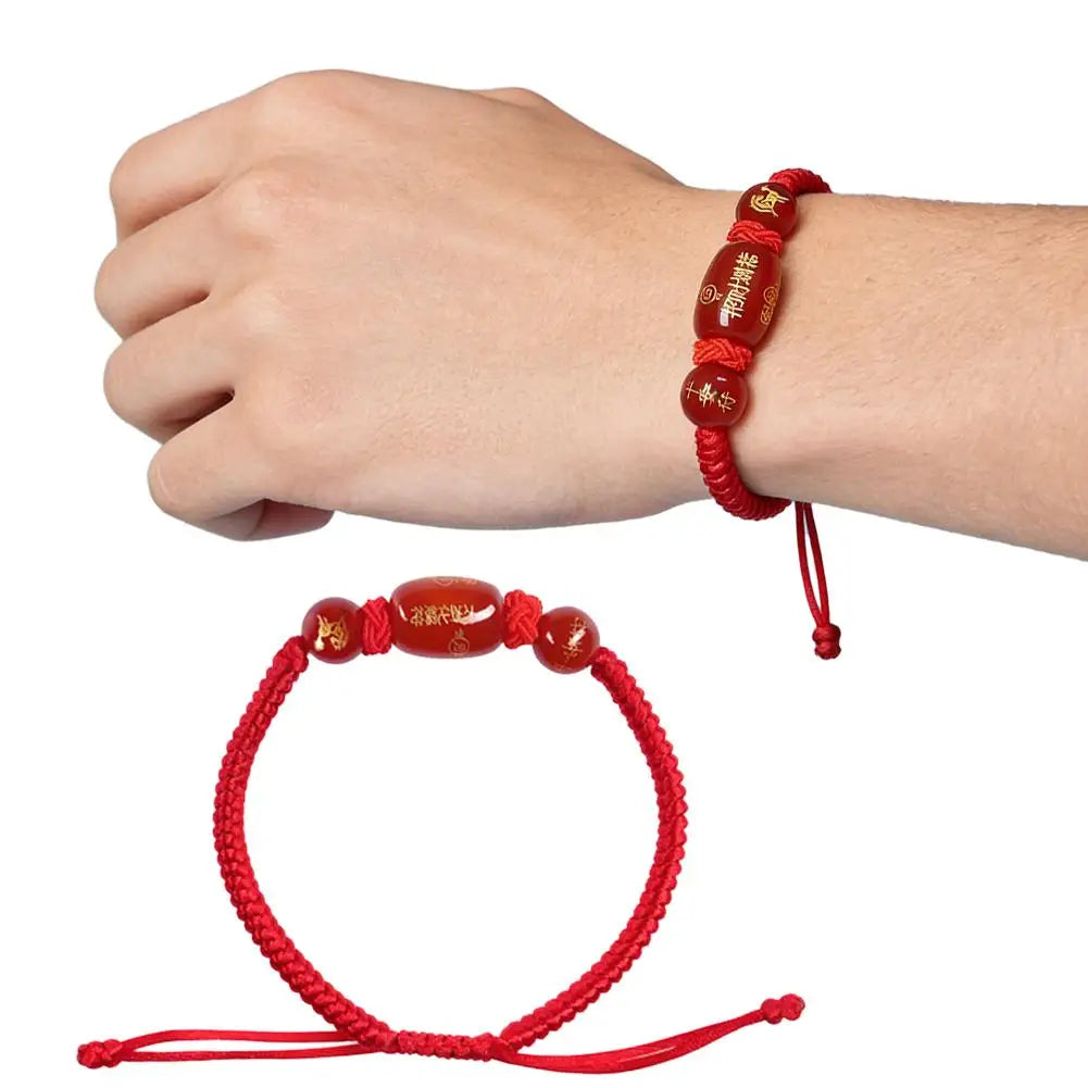 Red string bracelets with gold beads on a white background