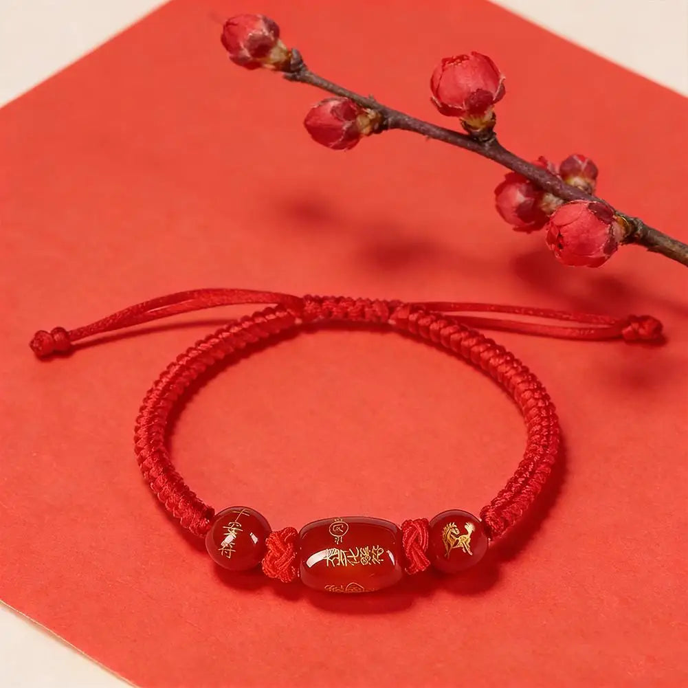 Red bracelet with beads on a red background