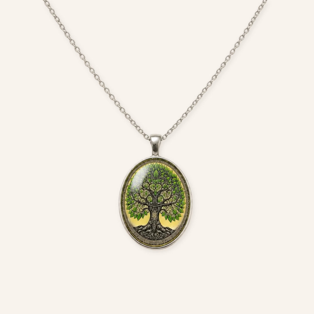 Vintage Tree of Life Necklace featuring a silver-tone chain, oval Tree of Life pendant, green leaf details, and vintage-inspired botanical artwork in a clean product image.