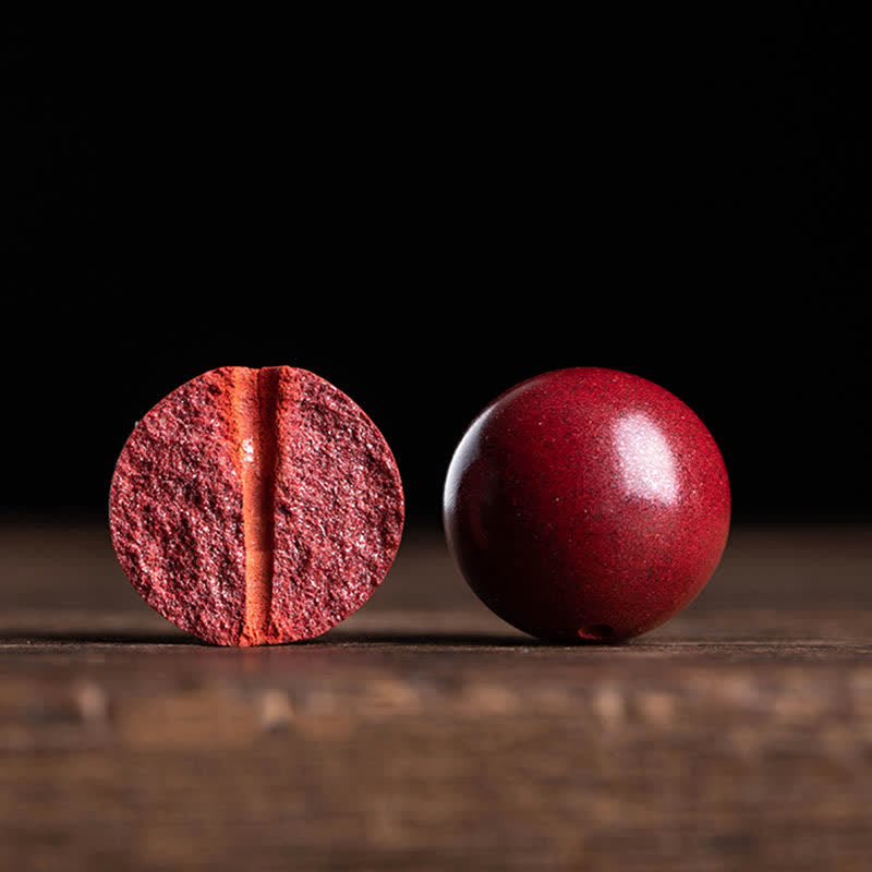 Red berry cut in half on a wooden surface with a dark background
