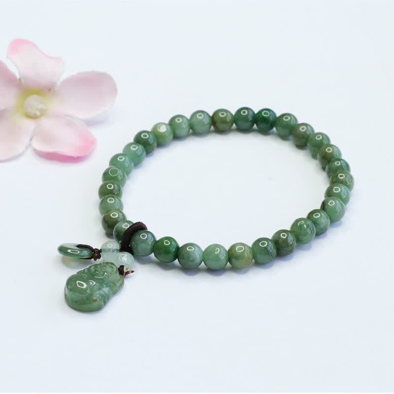 Green beaded bracelet with a pendant on a white background