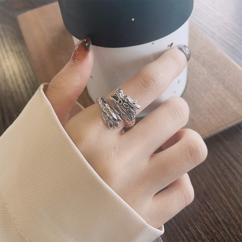 Hand wearing a silver ring with a blurred background