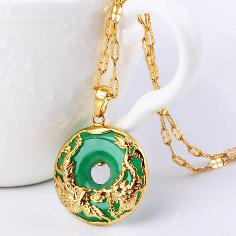 Gold necklace with a green pendant on a white background