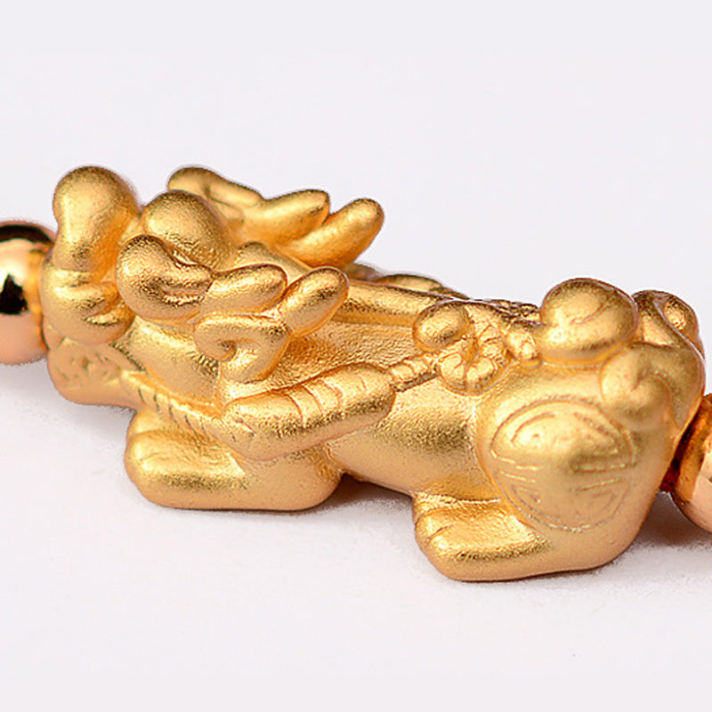 Gold dragon-shaped bracelet on a white background