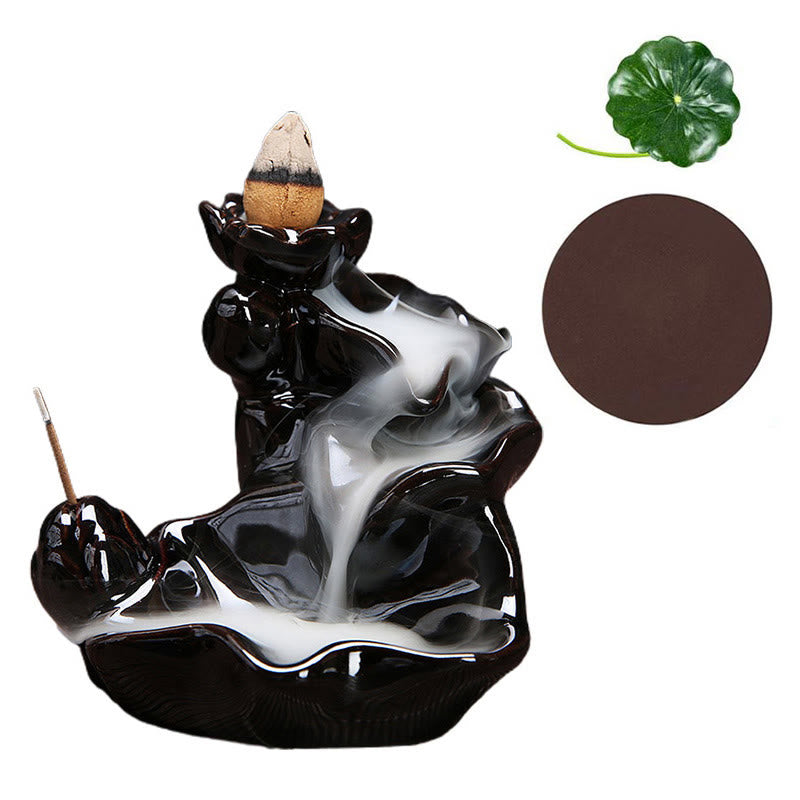 Black and white ceramic incense burner with incense sticks on a white background