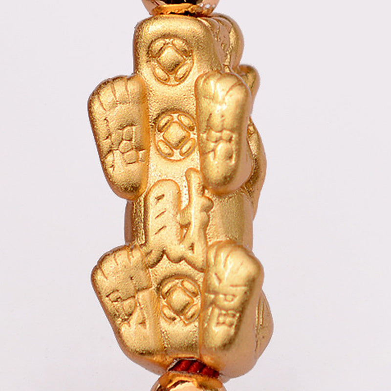Gold pendant with intricate designs and characters on a white background