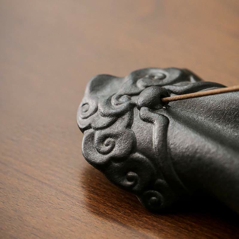 Decorative metal piece with intricate designs on a wooden surface