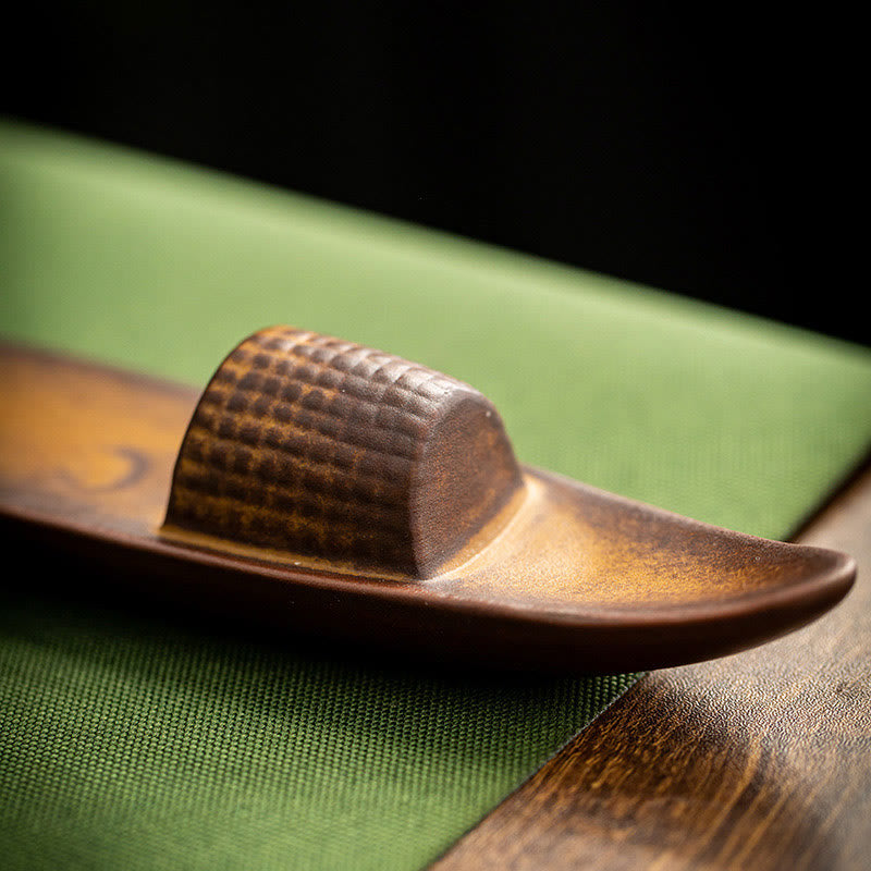 Wooden sandal with textured strap on a green surface