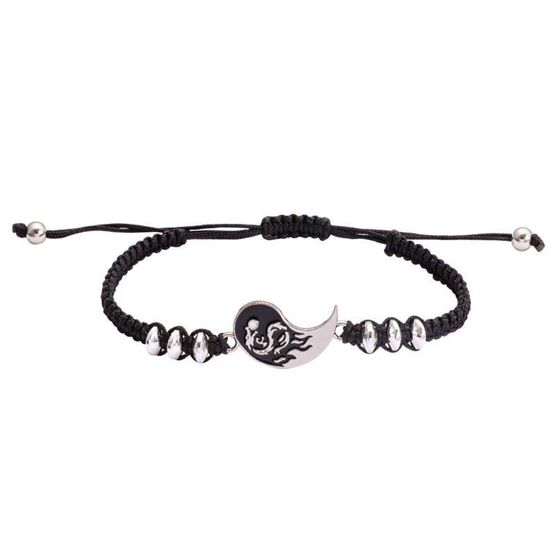 Black braided bracelet with a yin yang charm on a white background