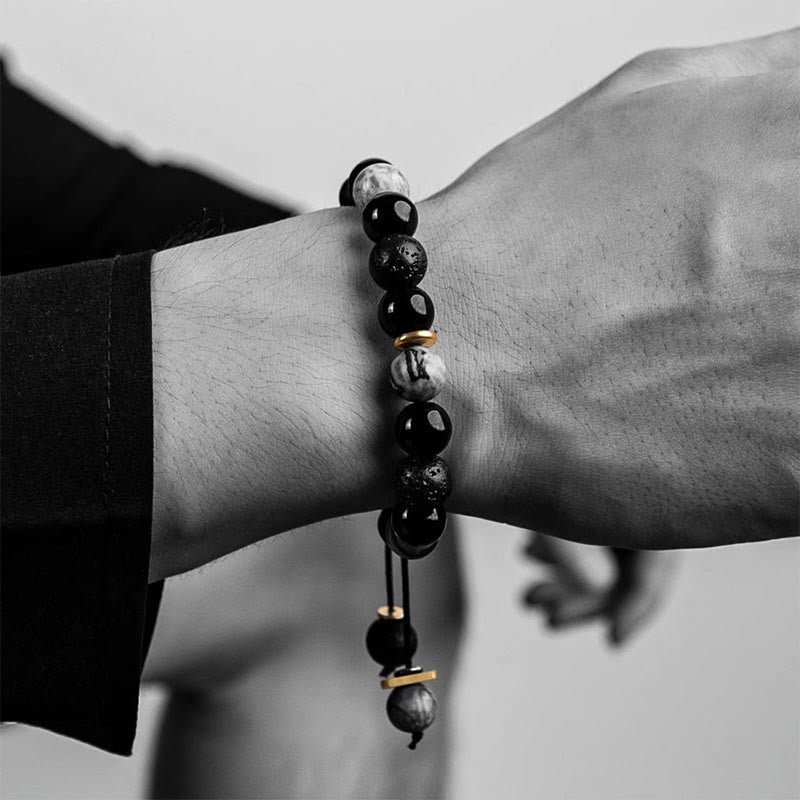 Black beaded bracelet on a wrist with a blurred background