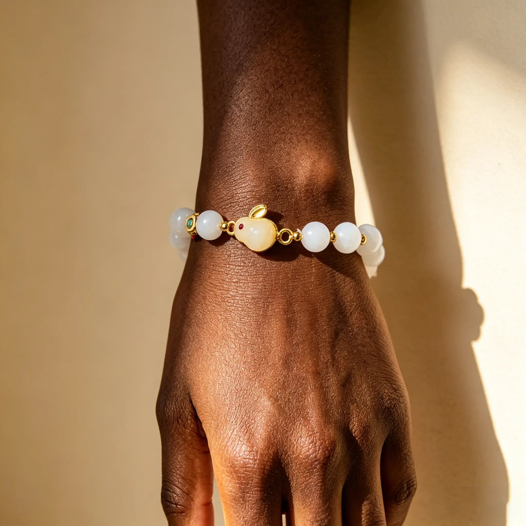 Golden Silk Jade Cute Rabbit Good Luck Bracelet worn on the wrist with white beads and gold details