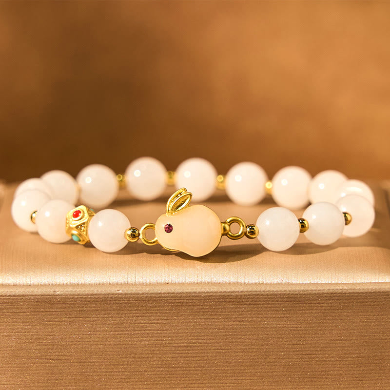 Detail view of Golden Silk Jade Cute Rabbit Good Luck Bracelet on a wooden surface