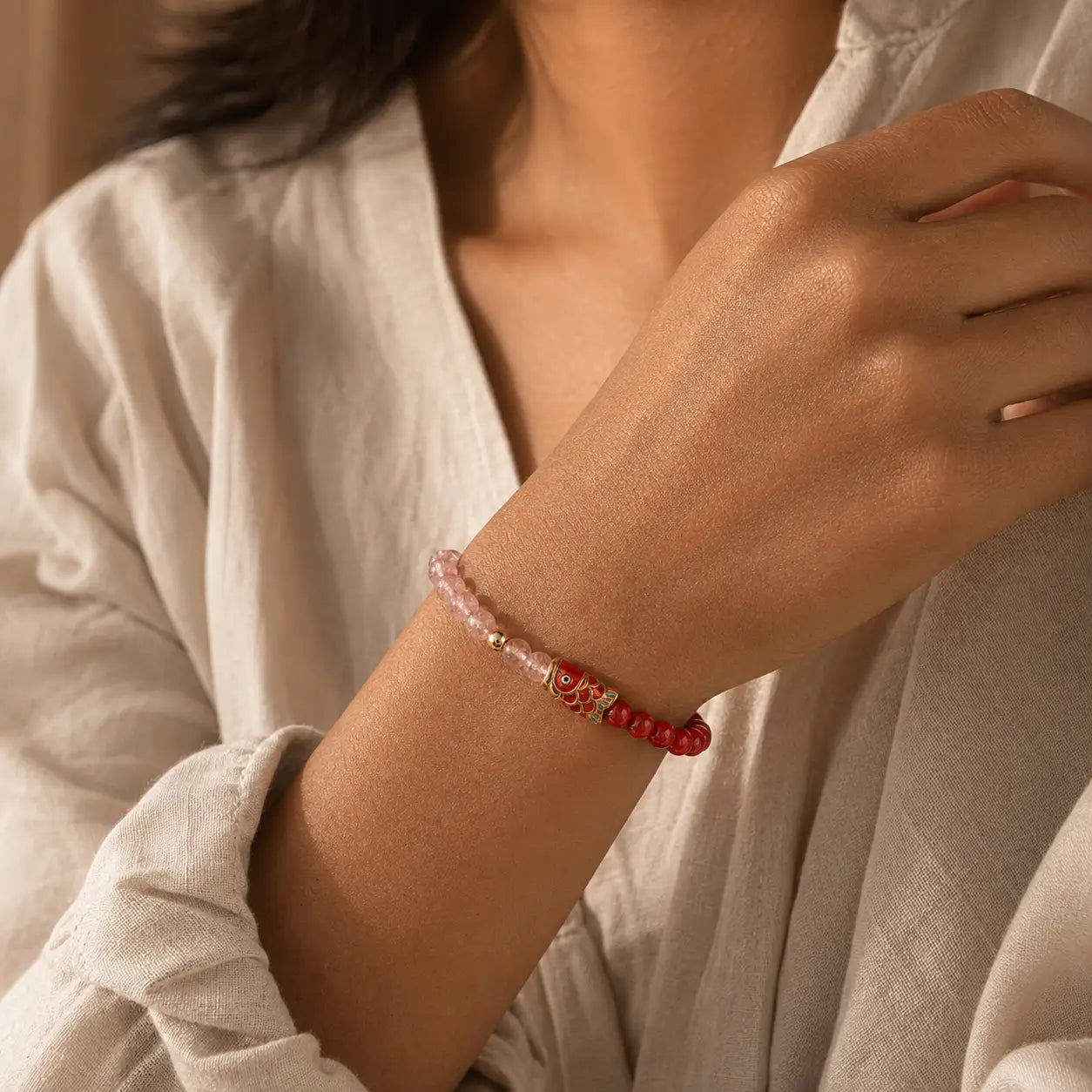 Fortune Koi Pink Glass Bead Bracelet worn on the wrist with red and pink bead details