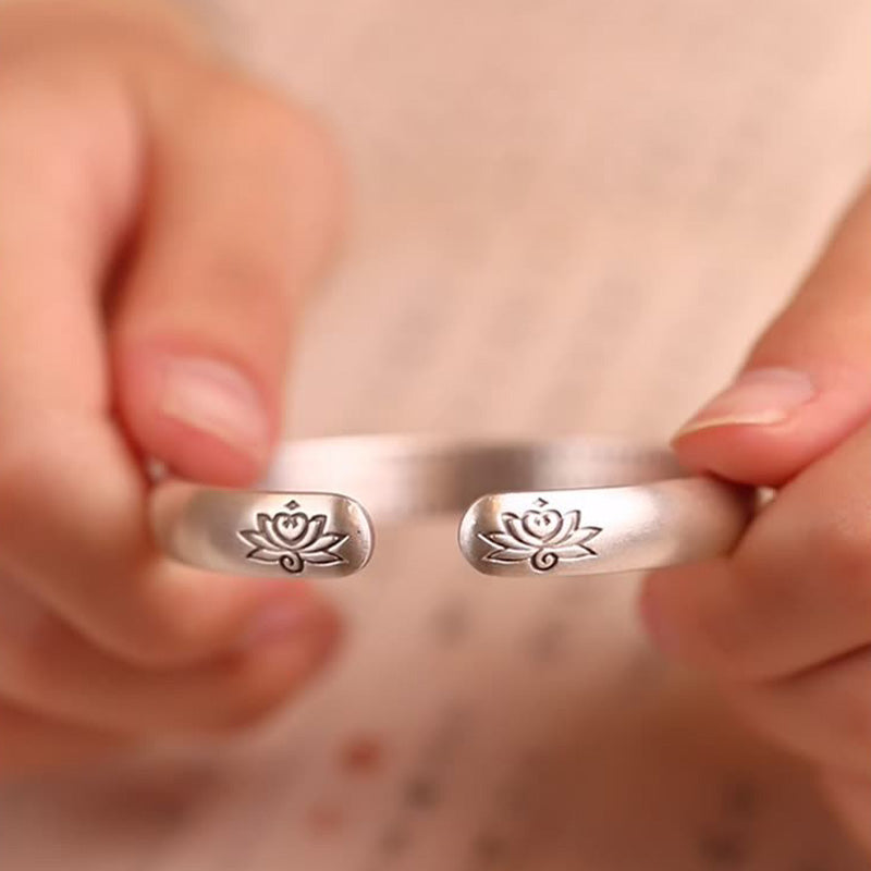 Hand wearing TheFuMaster silver lotus engraved bangle symbolizing serenity and mindfulness