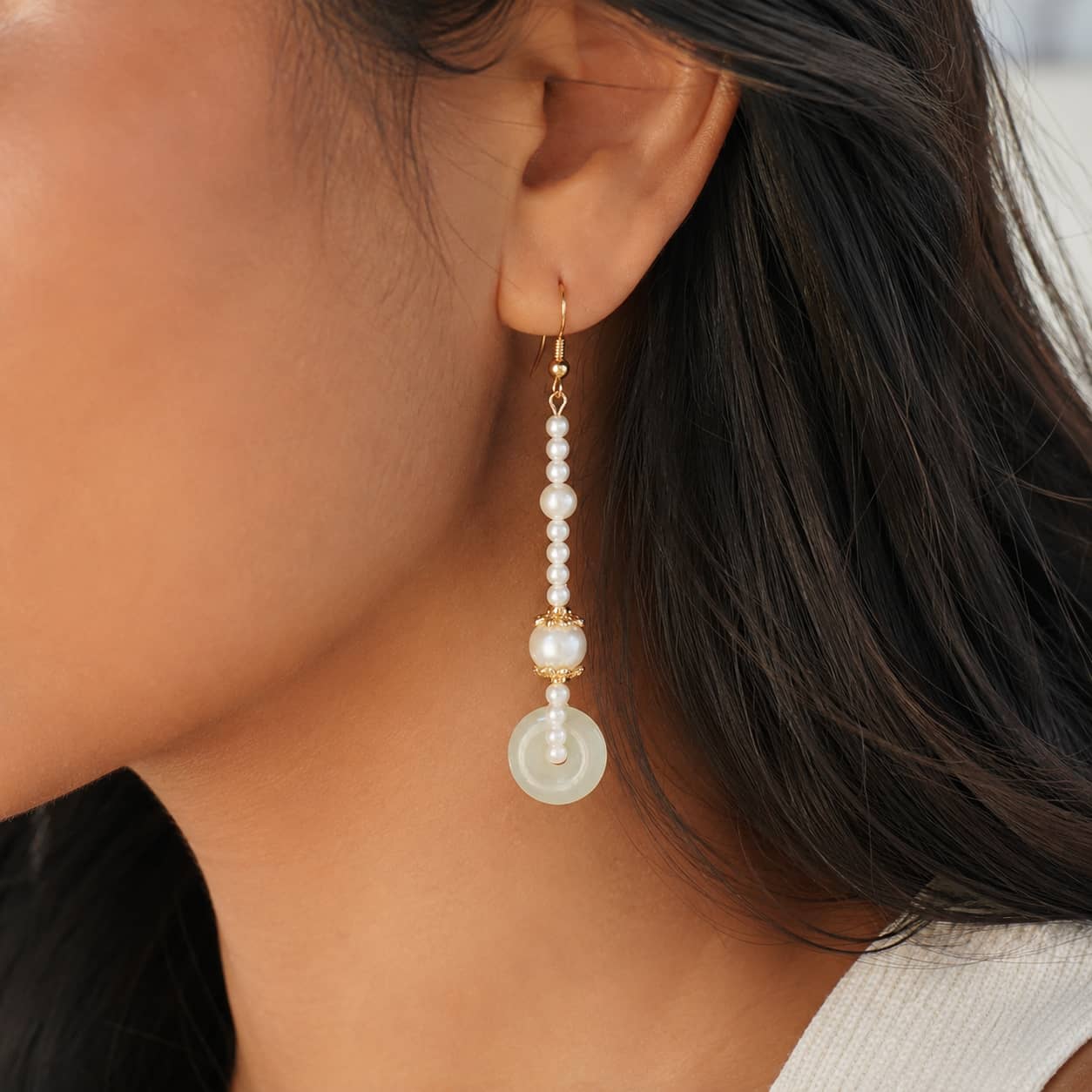 Close-up of Peace Buckle Pearl Drop Earrings
