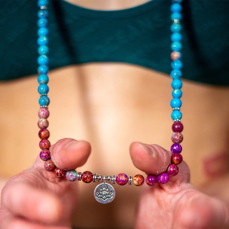 Purple Miano mala necklace held in meditation hand pose – TheFuMaster