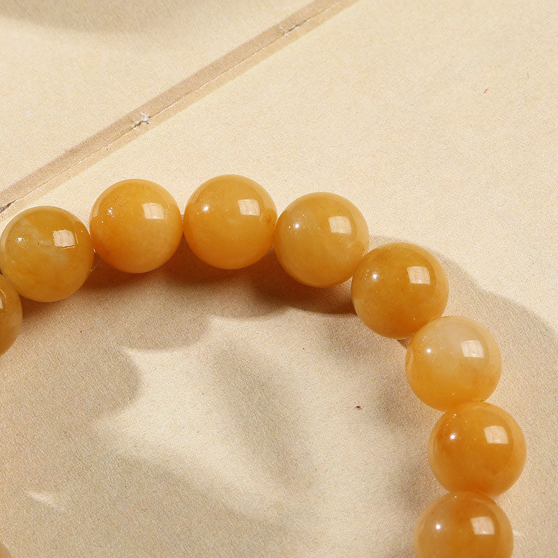 Close-up of polished golden jade beads reflecting light – TheFuMaster
