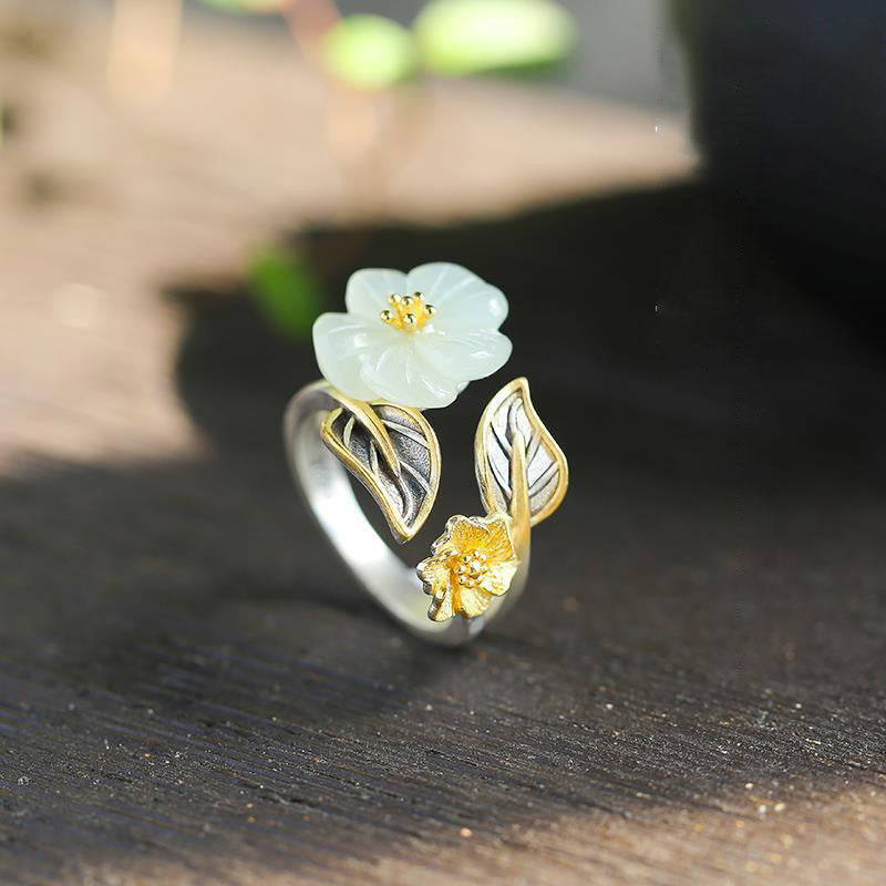 Angled product shot of the White Jade Plum Flower Leaf Ring showing flower and leaf design from side view
