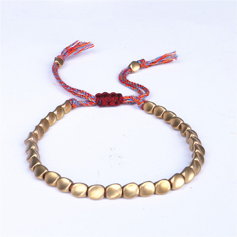 Detailed image of red-knot Tibetan Copper Luck Bracelet symbolizing good fortune and protection.