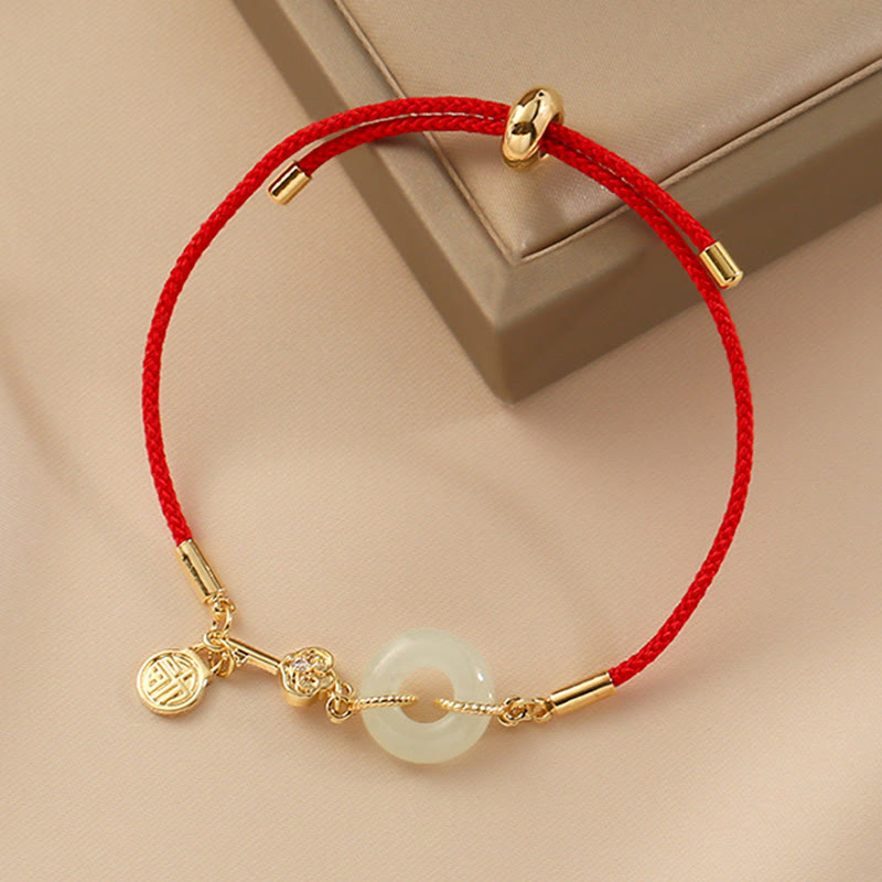 Flatlay view of TheFuMaster Hetian jade Peace Bracelet on red rope — elegant and minimal energy jewelry