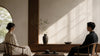 Calm difficult conversation in a quiet neutral room for grounded boundaries