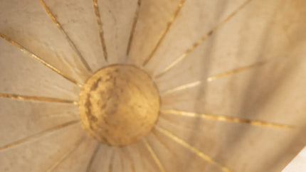 Warm summer solstice light through a paper parasol for seasonal intention
