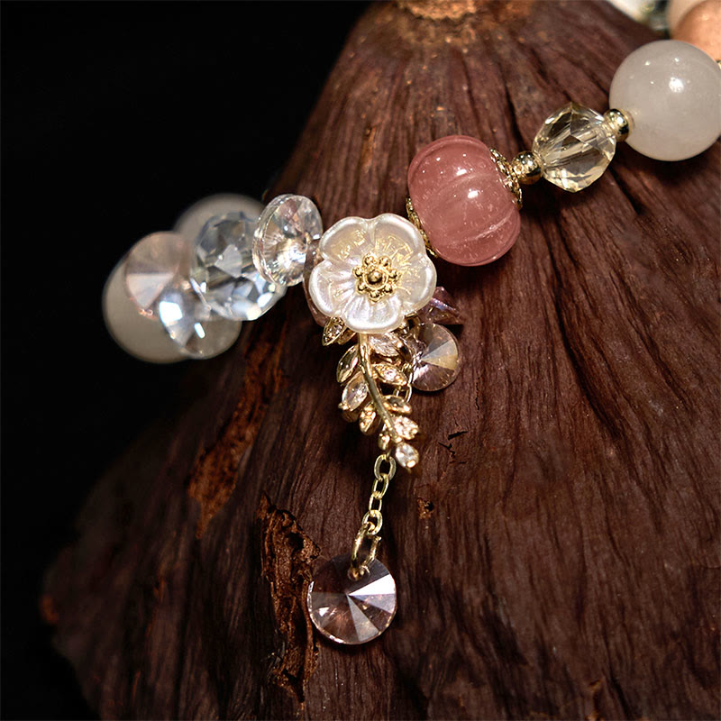 Delicate bracelet with floral design and gemstones on a wooden surface