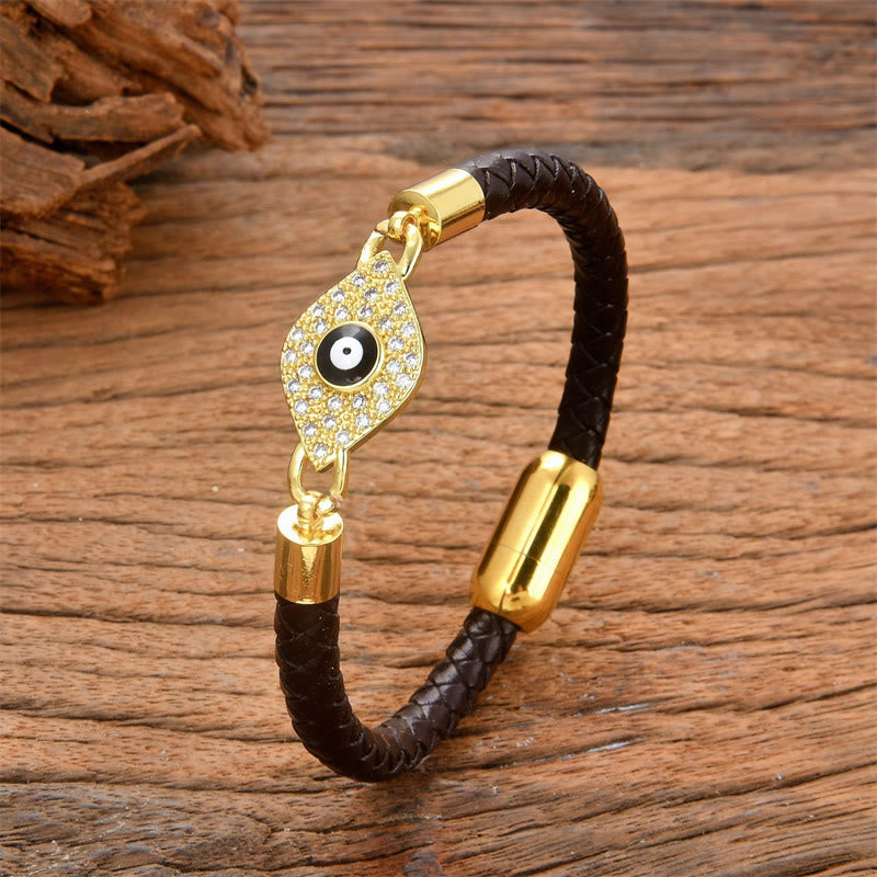 Bracelet with gold evil eye charm on a wooden surface