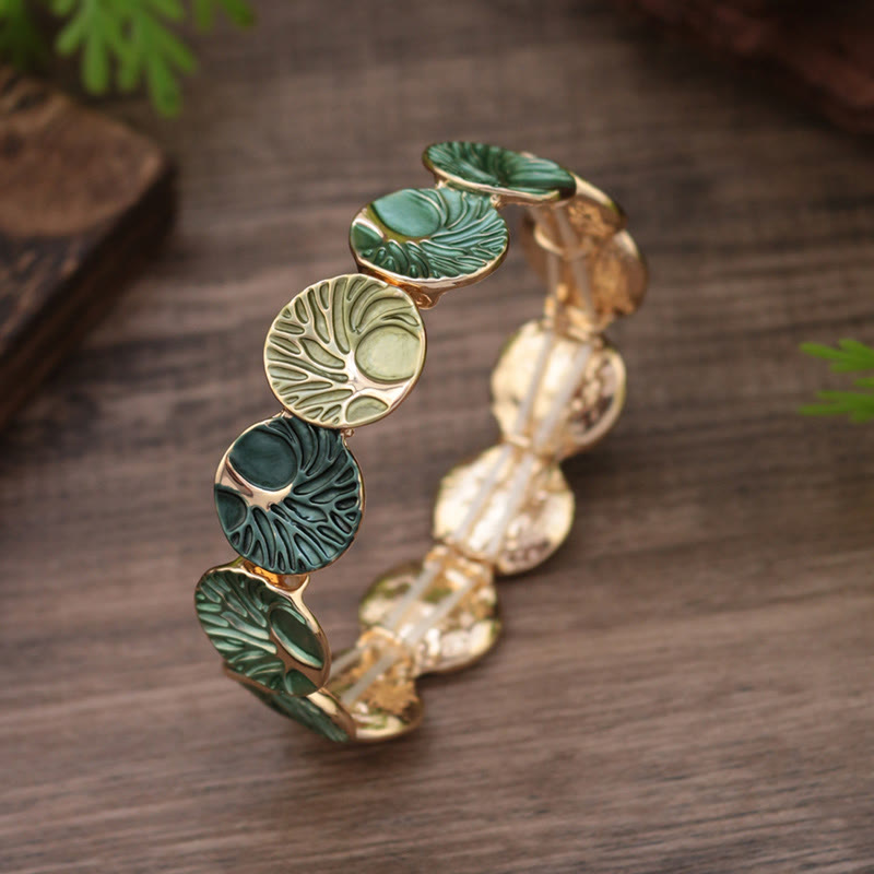 Bracelet with green leaf-like beads on a wooden surface