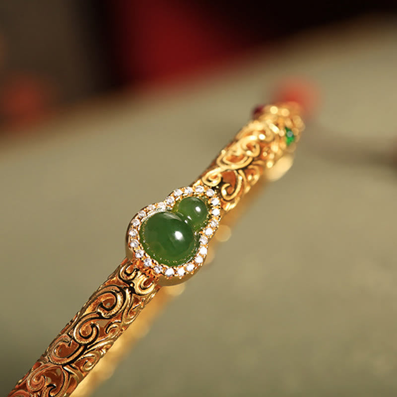 Crafted with traditional gold filigree technique, the bracelet features intricate auspicious cloud patterns and a central natural Hetian碧玉 gourd pendant, symbolizing "blessings and prosperity". The fusion of gold and jade exudes both elegance and profound Eastern cultural meaning, making it a perfect choice for daily wear or collection.