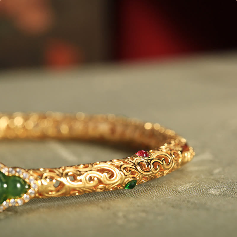 Crafted with traditional gold filigree technique, the bracelet features intricate auspicious cloud patterns and a central natural Hetian碧玉 gourd pendant, symbolizing "blessings and prosperity". The fusion of gold and jade exudes both elegance and profound Eastern cultural meaning, making it a perfect choice for daily wear or collection.