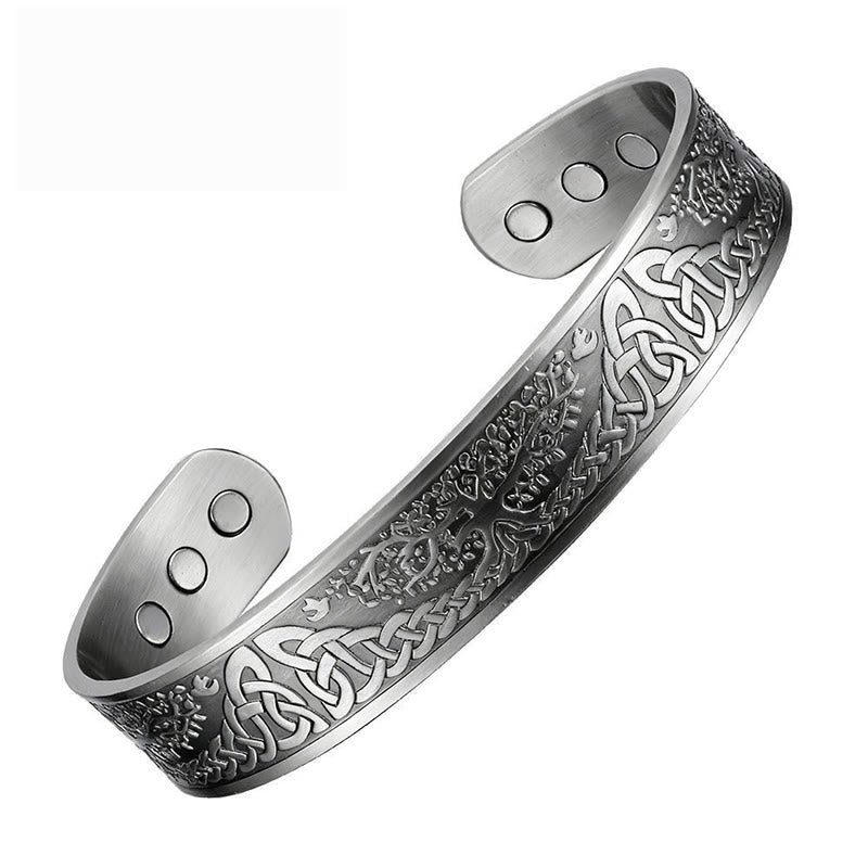 Silver bracelet with intricate designs on a white background