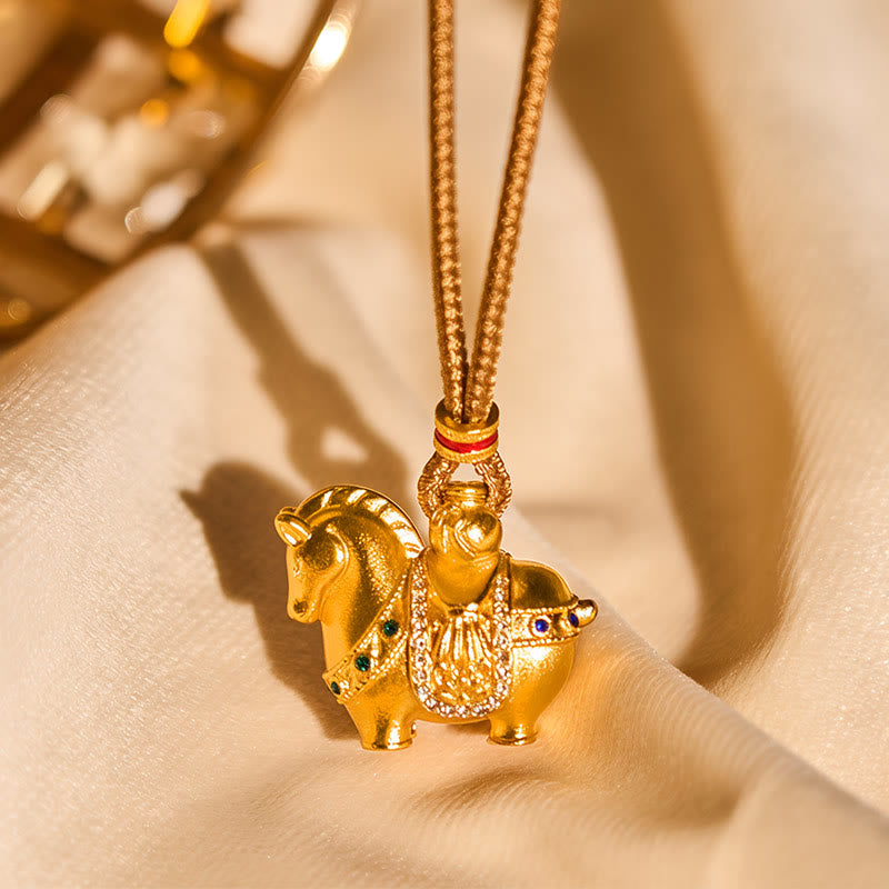 Gold animal-shaped pendant on a chain against a beige background