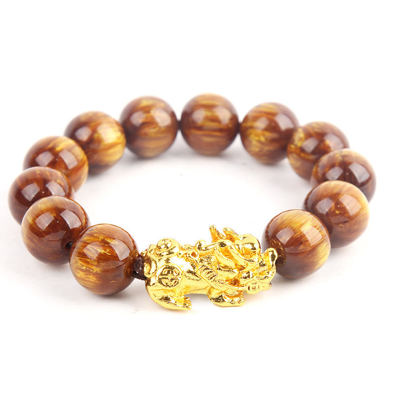 Bracelet with brown beads and a gold dragon charm on a white background