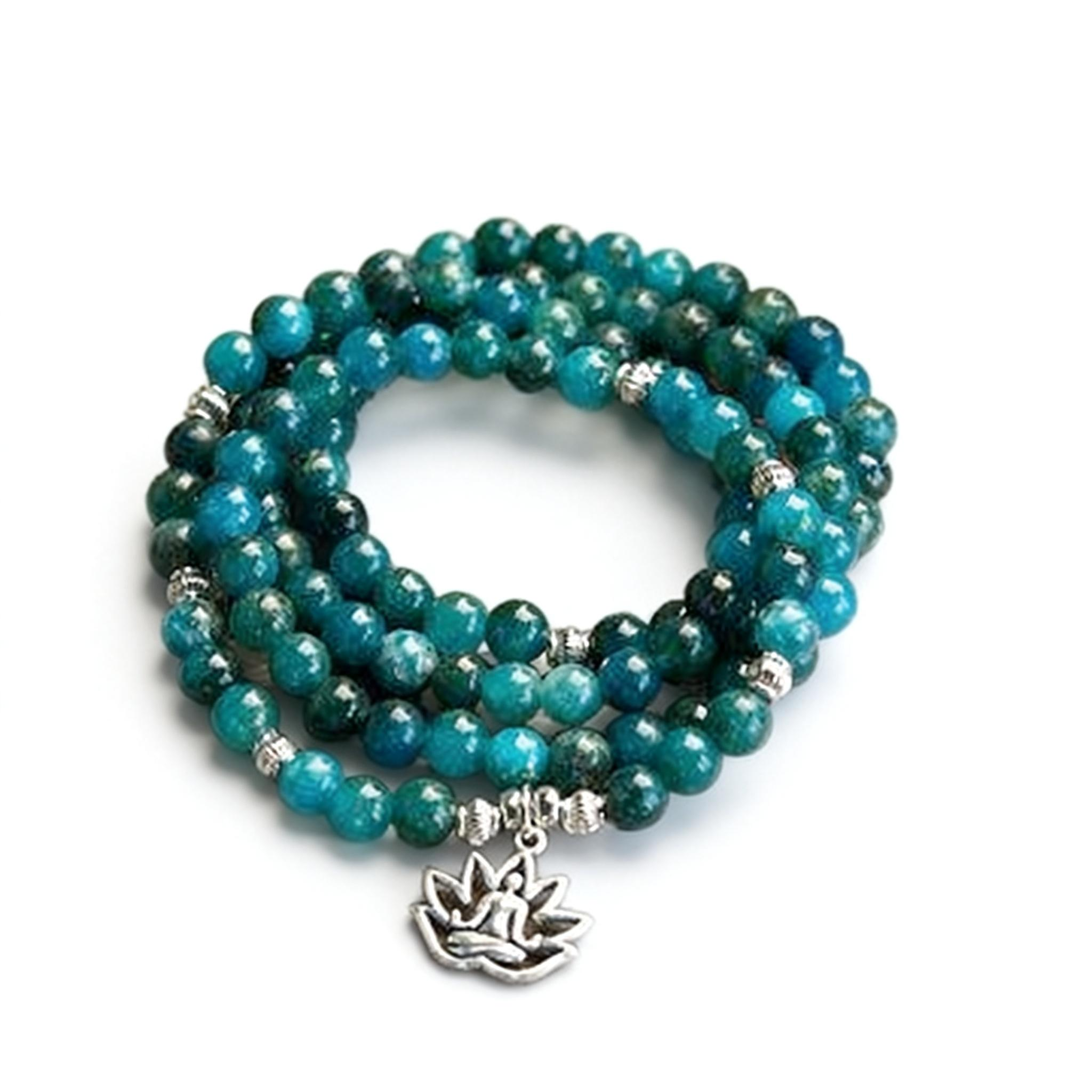 Turquoise beaded bracelet with a silver lotus charm on a white background