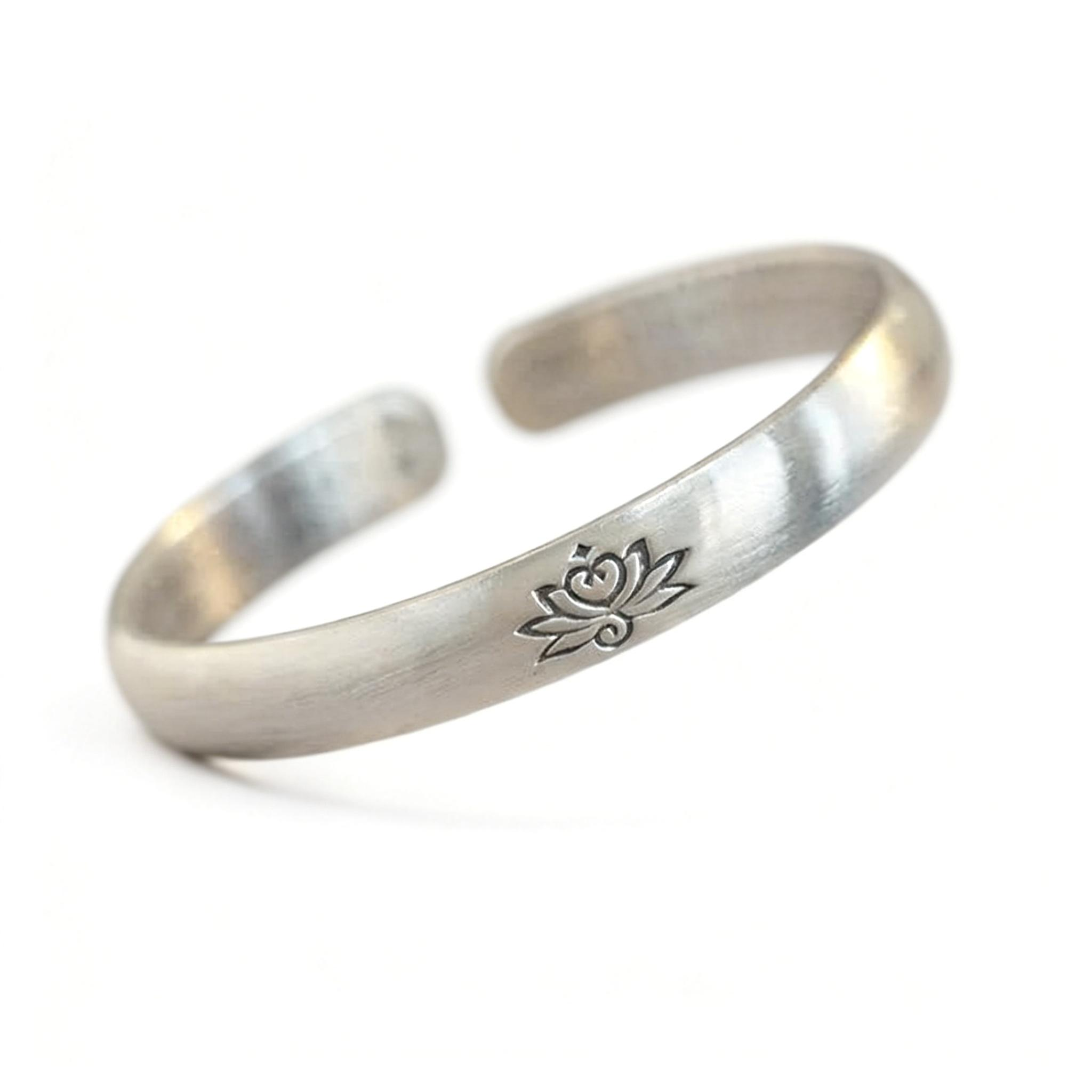 Silver bracelet with a lotus flower design on a white background