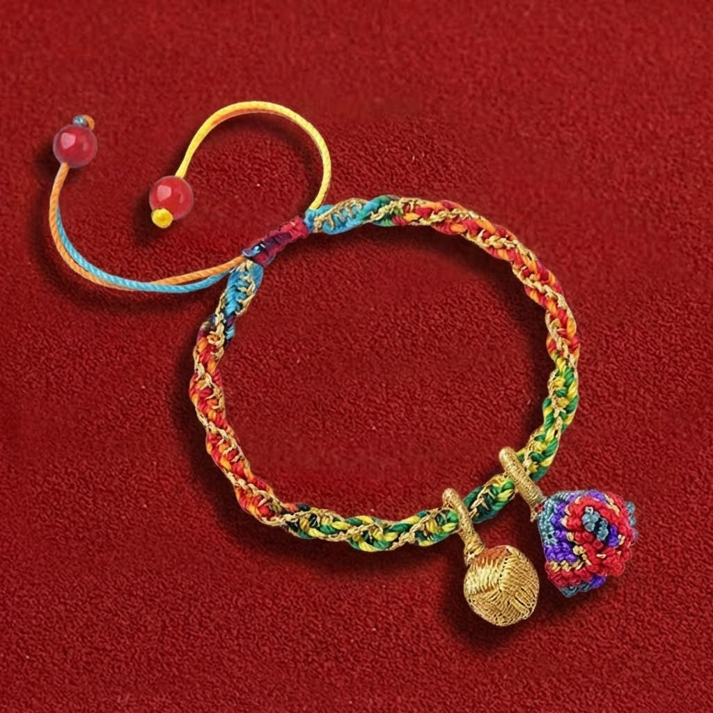 Colorful braided bracelet with charms on a red background